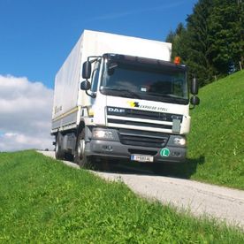 weißer Transporter von Transportunternehmen auf kleiner Landstraße in Vomp nahe Innsbruck